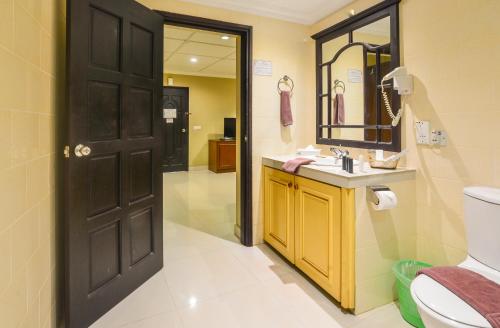 安西沃尔伯特村普拉兰岛成功度假村的浴室设有黑色门、盥洗盆和卫生间。