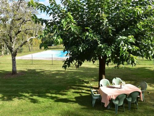 Saint-PompontVintage Holiday Home in Besse with Swimming Pool的公园树下桌椅