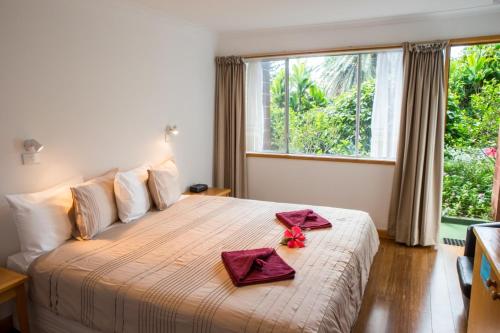 彭特派因Seaview Norfolk Island的一间卧室配有一张大床,上面有红色的餐巾