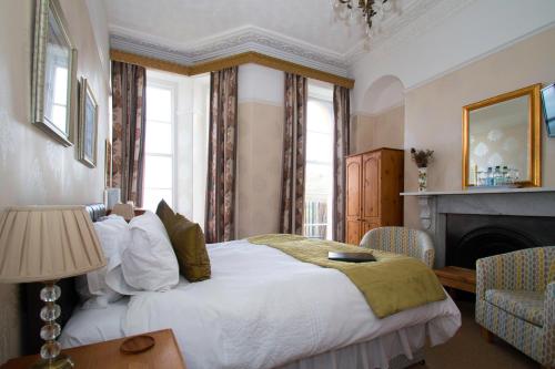 伊尔弗勒科姆科林代尔酒店的一间卧室设有一张大床和一个壁炉