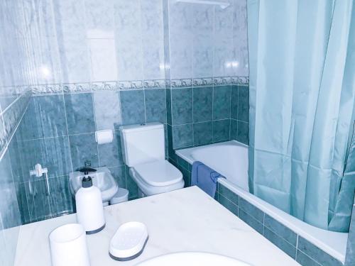 拉戈阿Apartamento T2 Carvoeiro-Lagoa preços acessíveis的浴室配有卫生间、浴缸和水槽。