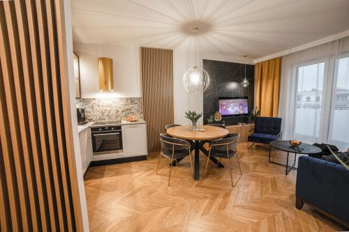 奥尔什丁Apartament Warmiński by RENT4YOU的厨房以及带桌椅的起居室。