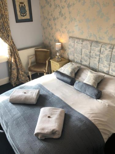 巴斯Devonshire House的一间卧室配有一张床,上面有两条毛巾