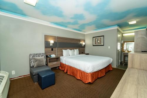 洛杉矶好莱坞棕榈旅馆&套房酒店的配有一张床和一把椅子的酒店客房