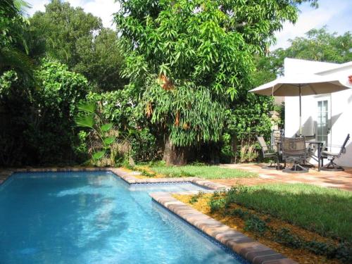 西棕榈滩Casa Blanca 2bd 2ba Private Pool and Parking的一个带遮阳伞的庭院内的游泳池