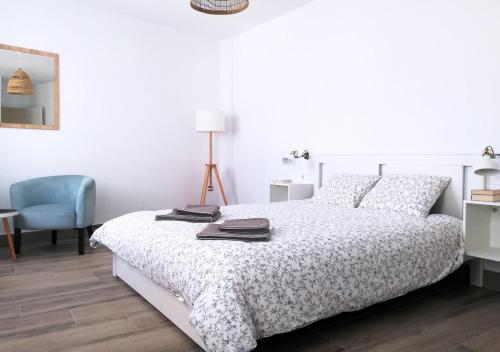 莫切Dunas Jewel Apartment的白色卧室配有床和蓝椅