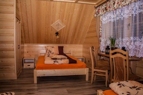SablówkaChatka Pod Laskiem - Domki w górach的卧室配有一张床和一张桌子
