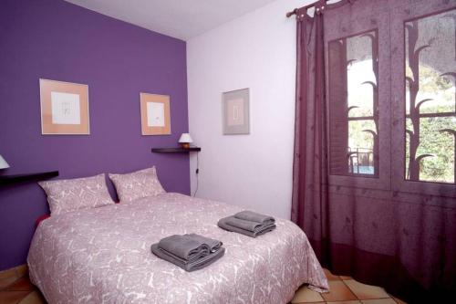 萨洛La Casa del Bosc, playa y golf - Salou的一间卧室配有一张紫色墙壁和窗户的床