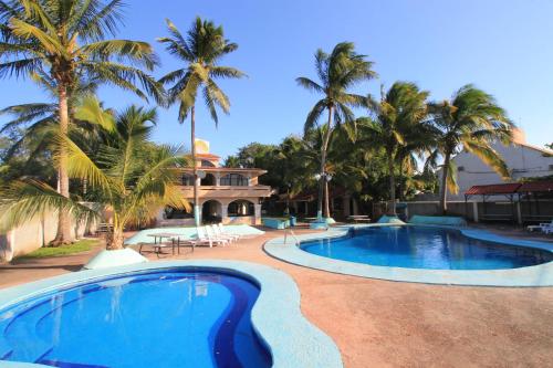 查察拉卡斯Hotel Gran Palmeiras的一座棕榈树游泳池和一座房子