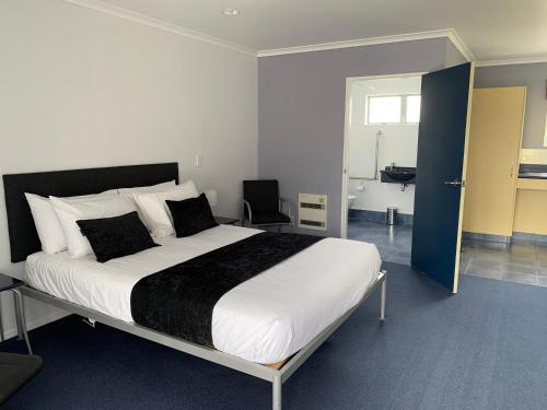  Waipukurau菲儿古松斯汽车旅馆的一间带大床的卧室和一间浴室