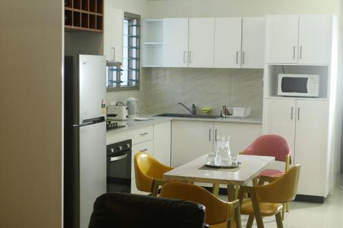 苏瓦FIJI HOME Apartment Hotel的厨房配有白色橱柜和桌椅