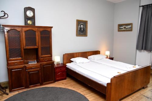 索非亚Santa Sofia的一间卧室配有一张床、一个橱柜和一个时钟