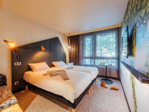 鲁昂Ibis Styles Rouen Centre Rive Gauche的酒店客房设有两张床和大窗户。