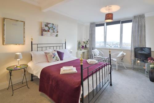 斯卡伯勒Scarborough-Penthouse, with private balcony, lift and parking的一间卧室配有一张床和一台电视。