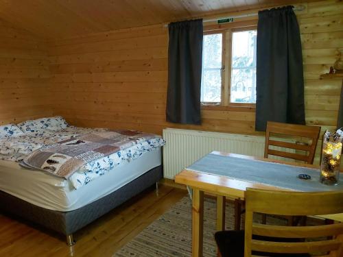 阿克雷里Bakkakot 2 - Cozy Cabins in the Woods的一间卧室配有一张床、一张桌子和一个窗户。