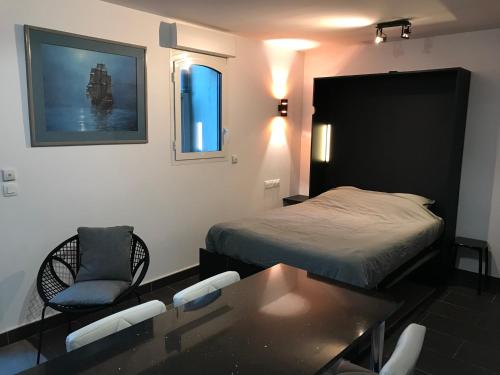 圣马洛Studio Le sillon malouin vue mer的卧室配有一张床和一张桌子及椅子