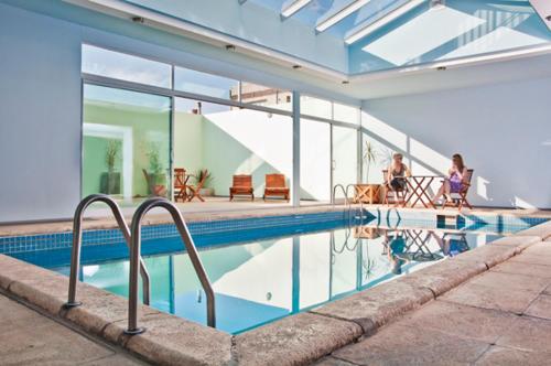 圣路易斯昆塔娜酒店的一座房子,设有一座游泳池,背景人员
