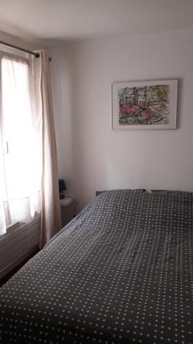 圣日耳曼昂莱Appartement cosy dans le centre historique的一间卧室设有一张床和一个窗口