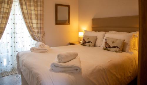 本莱赫The Cottage的卧室配有白色床和毛巾
