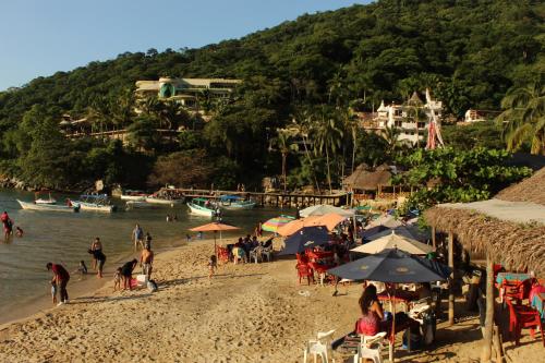 巴亚尔塔港La Posada Pacifica的一群人在海滩上,带遮阳伞