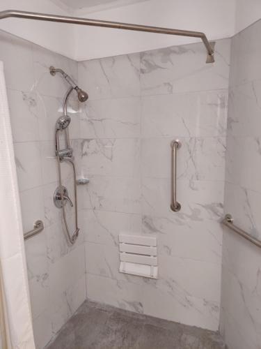 康沃尔哈德逊卡德特汽车旅馆的浴室设有白色大理石瓷砖和淋浴。