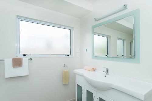 吉斯伯恩AhiKaa Gisborne Motel的白色的浴室设有水槽和镜子