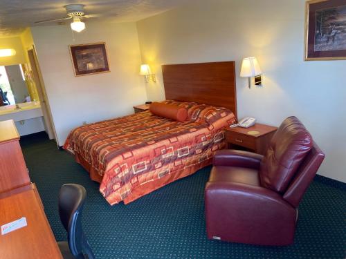 尤宁城Country Hearth Inn-Union City的配有一张床和一把椅子的酒店客房
