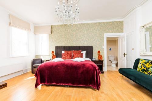 朴次茅斯Ashbys Accommodation & Spa hire的一间卧室配有一张大床和一个吊灯。
