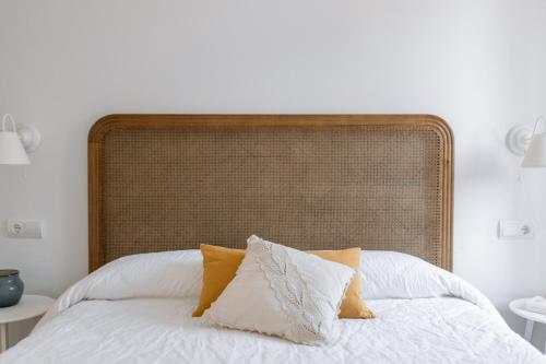 帕拉莫斯Ecoturisme Mas Ribas的一张带白色床单和黄色枕头的床