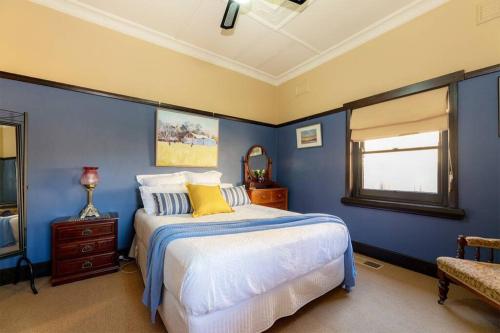 奥尔伯里Cullalo ArtHouse的蓝色的卧室设有床和窗户