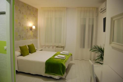 马德里Hostal PETITE MAMAN的一间卧室配有一张带绿毛巾的床