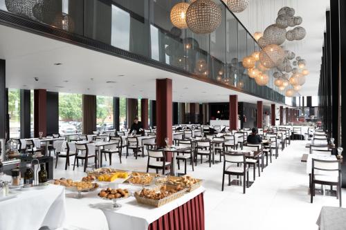 维亚纳堡阿克西斯维亚纳商务SPA酒店的一间餐厅配有桌椅,提供食物