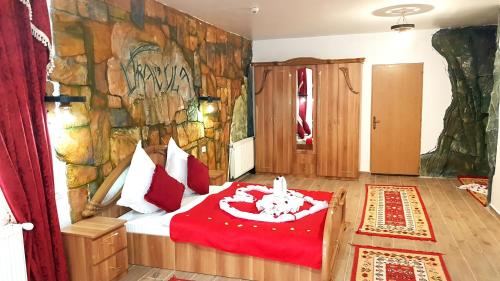 Căpăţîneni-UngureniComplex Dracula & Spa的卧室在石墙前配有一张床