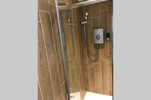 布里斯托Alison15 - Superior Clifton Studio Apartment的带淋浴的浴室(带木墙)