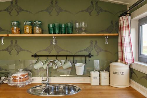 FelbriggThe Covey的厨房柜台设有水槽和带杯子的架子