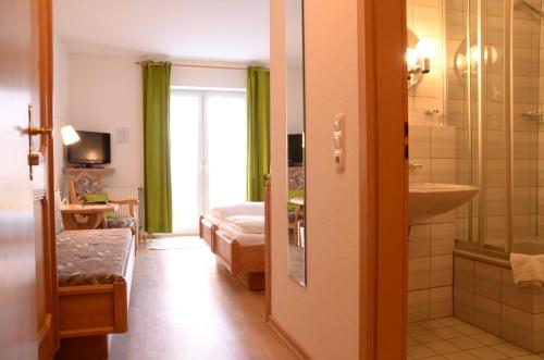 吕贝克特威豪斯加尼森林酒店的客房设有带一张床和盥洗盆的浴室