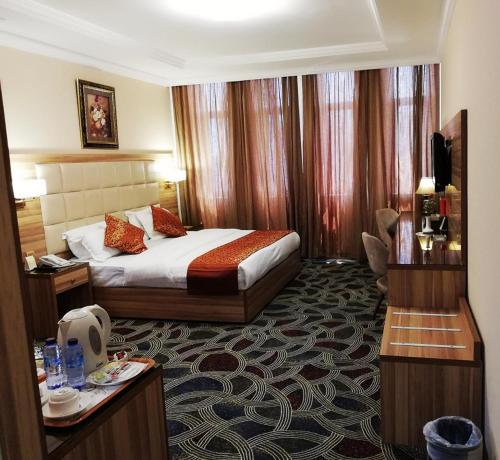 吉达罗山艾尔阿扎酒店的配有一张床和一张书桌的酒店客房