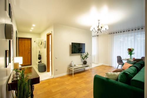 尼古拉耶夫Luxury Apartment with 2 bedrooms in the city center的客厅配有绿色沙发和桌子