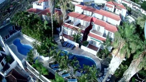 Los QuemadosApartamentos colon y bungalows的享有带游泳池的度假村的空中景致