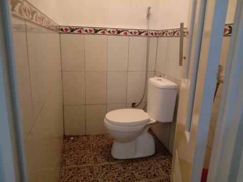 日惹鲁玛优齐旅馆的一间位于客房内的白色卫生间的浴室