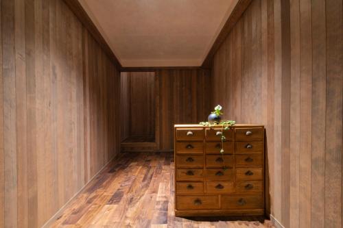 金泽HOTEL 101 KANAZAWA的木墙和木质梳妆台的房间