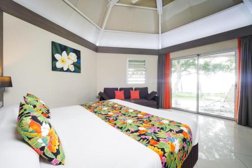 延根科洛村酒店的一间卧室配有一张大白色的床和色彩缤纷的毯子