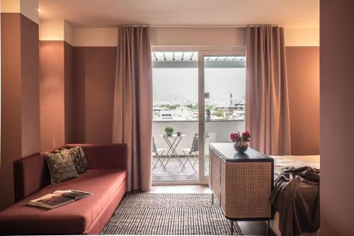 加尔达湖滨路易斯酒店的酒店客房设有沙发、床和阳台。