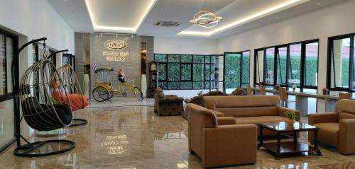 清迈Vista Hotel Chiang Mai - SHA EXTRA PLUS的客厅配有沙发,自行车在房间内