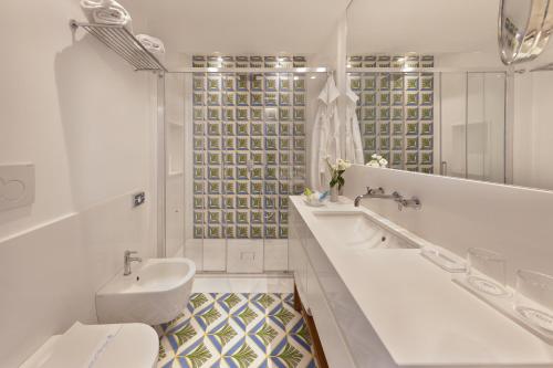 索伦托里维耶拉大酒店的白色的浴室设有水槽和卫生间。
