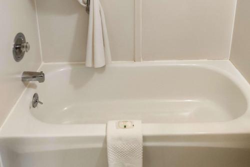 弗拉格斯塔夫Quality Inn Flagstaff East I-40的浴室设有白色浴缸,配有毛巾