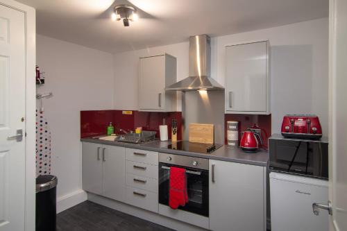 布莱克浦New Luxury Apt 1 Free Parking Special Deals的厨房配有白色橱柜和炉灶烤箱。
