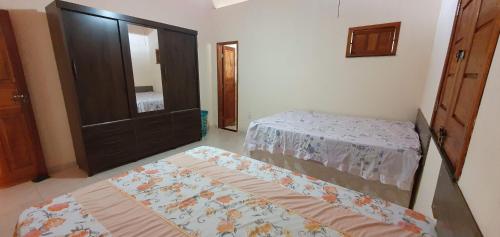 埃斯坦西亚Casa de Praia Abaís的一间卧室设有两张单人床和一面镜子