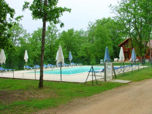 Lachapelle-AuzacMaison de 2 chambres avec vue sur le lac piscine partagee et jardin amenage a Lachapelle Auzac的一个带遮阳伞和遮阳伞的游泳池