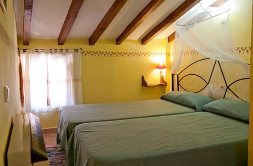 罗夫莱迪略德加塔One bedroom apartement with balcony and wifi at Robledillo de Gata的一间卧室设有两张床和窗户。